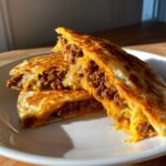 Close-up of cheesy, meaty Cheeseburger Quesadillas with Secret Sauce cut in half on a white plate.