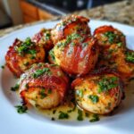 Close-up of perfectly cooked Cilantro Lime Bacon Wrapped Scallops garnished with fresh herbs on a white plate.