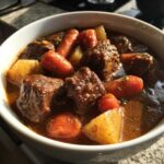 Close-up of rich Cowboy Beef Stew with Hearty Vegetables, featuring chunks of beef, carrots, and potatoes in a savory broth.