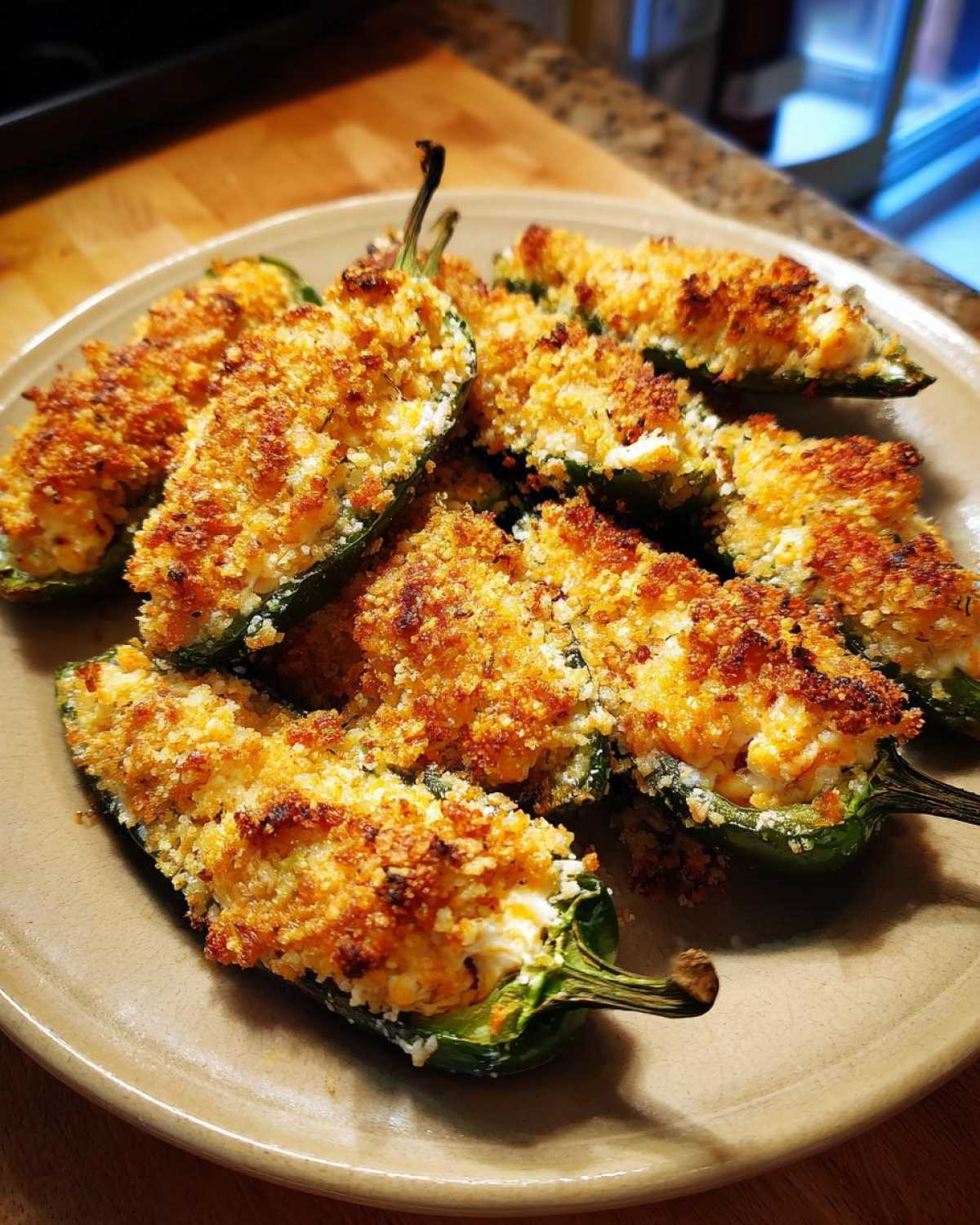 A plate of freshly baked Crab Stuffed Jalapeno Poppers with a golden, crispy breadcrumb topping.