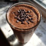 Overhead view of a rich Dark Chocolate Mint Breakfast Smoothie topped with mini chocolate chips.