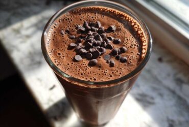 Overhead view of a rich Dark Chocolate Mint Breakfast Smoothie topped with mini chocolate chips.