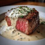 Cross-section of a medium-rare Filet Mignon with Gorgonzola Cream Sauce poured over the top.