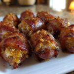 Close-up of several crispy, glazed Garlic Parmesan Bacon Wrapped Smokies arranged on a white platter.