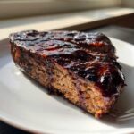 Close-up of a thick slice of Heart-Shaped Meatloaf with Balsamic Glaze, showing the moist texture and shiny topping.