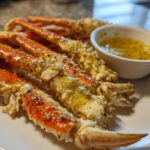 Close-up of cooked Dungeness Crab Legs seasoned with lemon pepper and served with melted butter.