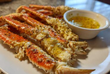 Close-up of cooked Dungeness Crab Legs seasoned with lemon pepper and served with melted butter.