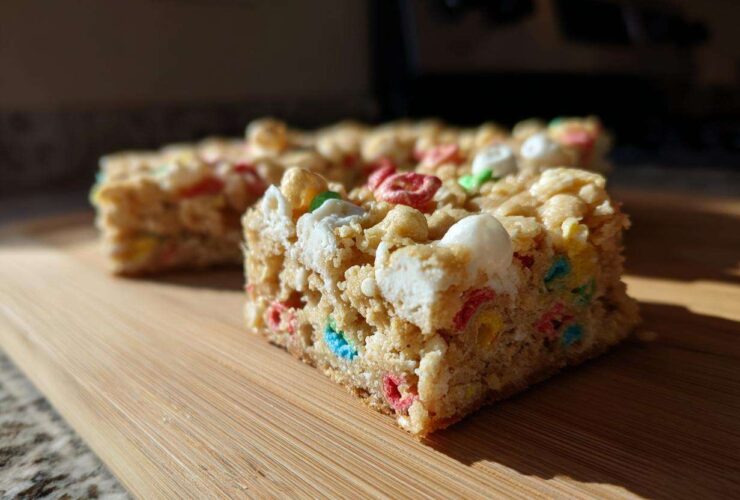 A close-up shot of a square of Lucky Charms White Chocolate Blondies, featuring colorful cereal pieces and marshmallows.