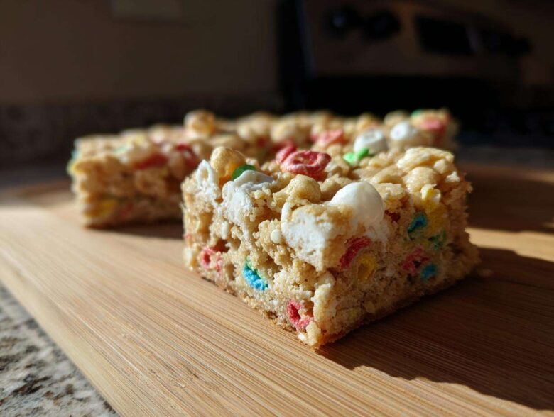 A close-up shot of a square of Lucky Charms White Chocolate Blondies, featuring colorful cereal pieces and marshmallows.
