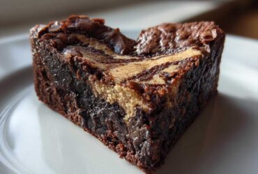 Close-up of a rich, fudgy Nutella Swirl Brownie Heart on a white plate, showing the marbled top.
