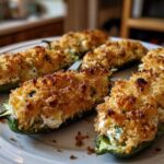Close-up of baked Pickle Stuffed Jalapeno Poppers with golden, crispy breadcrumb topping on a white plate.
