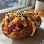 A single, fully loaded Reuben stuffed potato skins topped with corned beef, melted cheddar cheese, and a drizzle of Russian dressing.