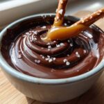 A pretzel dipped in rich, swirled Salted Caramel Chocolate Fondue topped with flaky sea salt.