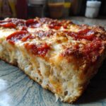 A thick, cheesy slice showing the layers of the 7-Layer Pizza Dip topped with pepperoni and melted mozzarella.