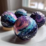 Four stunning White Chocolate Galaxy Painted Strawberries arranged on a white plate, featuring vibrant blue, purple, and pink swirls with silver edible glitter.