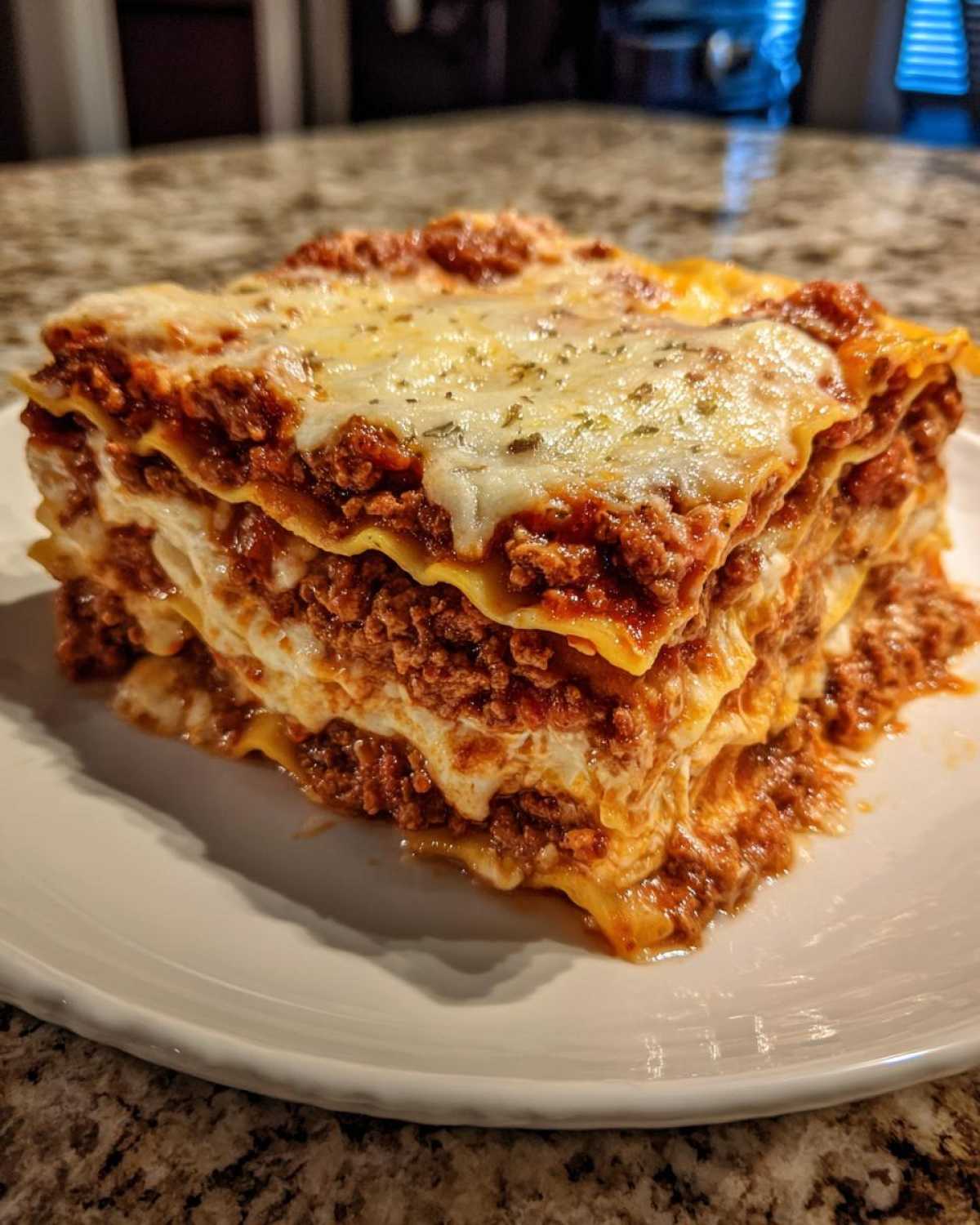 A thick, multi-layered slice of homemade lasagna with rich meat sauce and melted cheese topping.