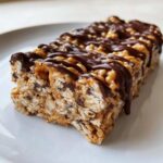 A close-up of a delicious, chewy homemade protein bars drizzled with dark chocolate.