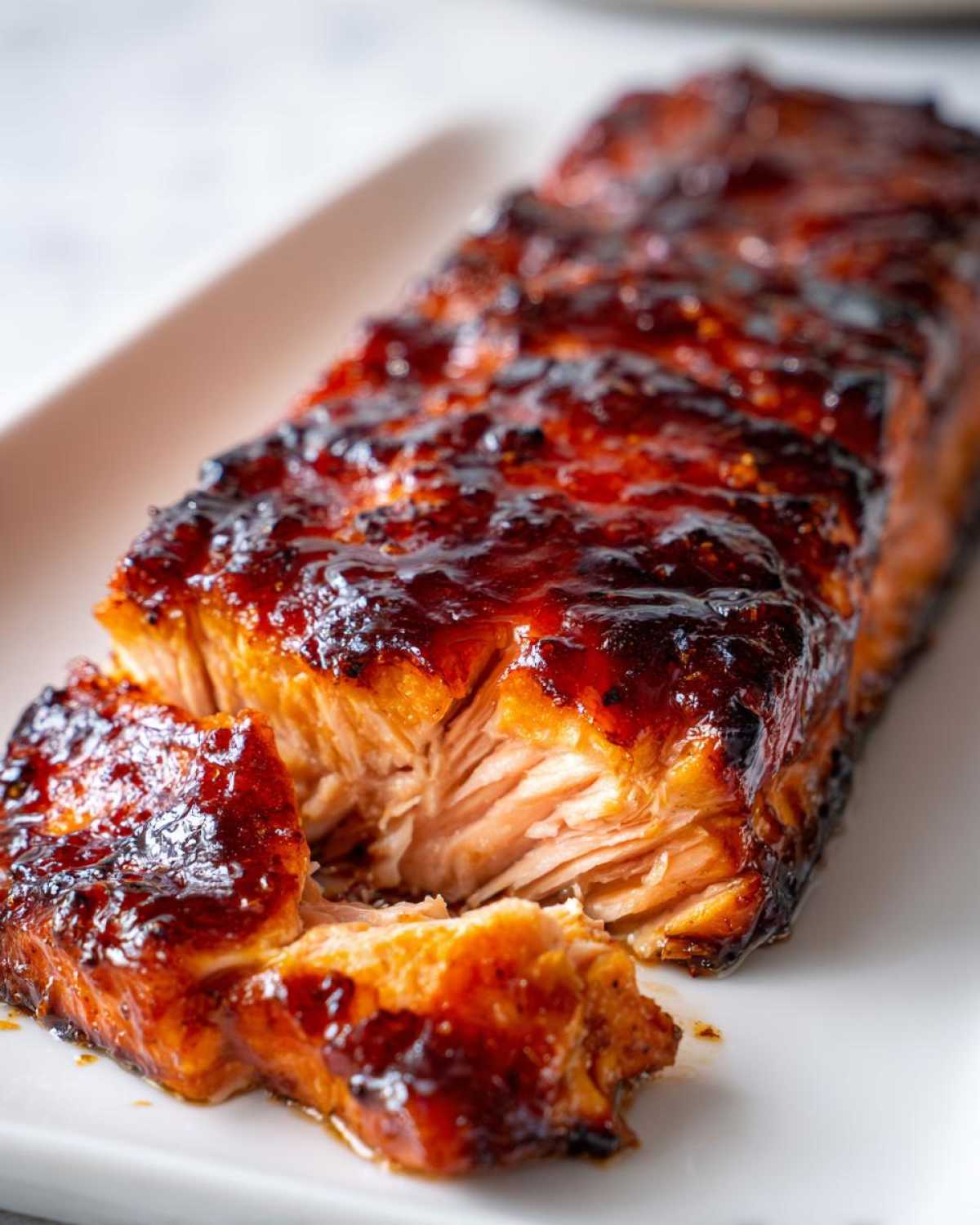 Close-up of a perfectly cooked, glazed salmon steak showing flaky texture and rich caramelized topping.