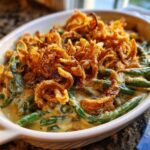 Close-up of a creamy green bean casserole topped generously with crispy fried onions.