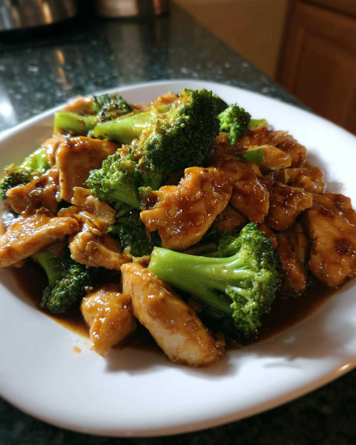 Close-up of tender pieces of chicken and bright green broccoli florets coated in a savory brown sauce, ready to eat chicken and broccoli.