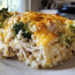 A close-up of a creamy slice of chicken broccoli rice casserole topped with melted cheddar cheese.