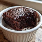 A rich, dark chocolate Cottage Cheese Microwave Brownie served warm in a white fluted ramekin.