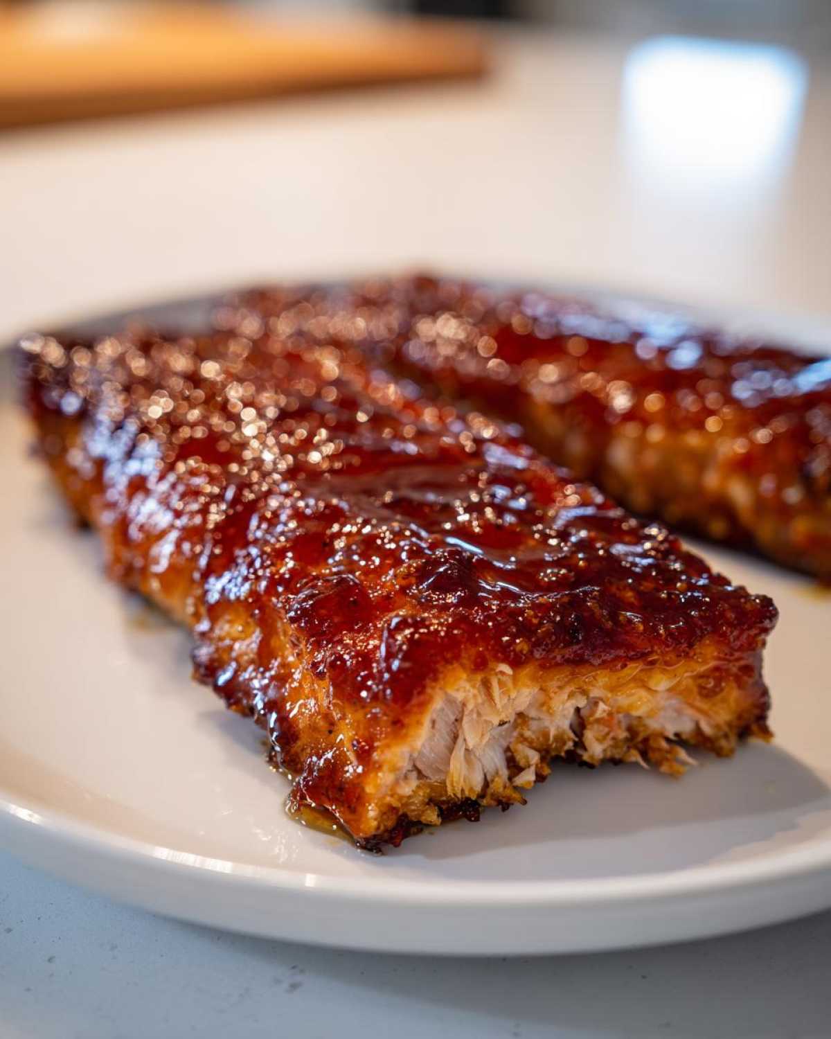 Close-up of a flaky, cooked salmon fillet covered in a thick, shiny brown glaze.