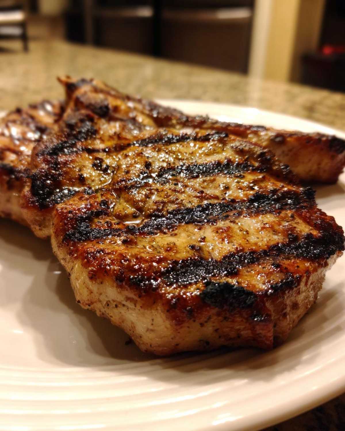Close-up of juicy, grilled pork chops showing distinct char marks from the grill, made using the best marinade for pork chops.