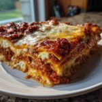 A thick, layered slice of Lasagna with Cottage Cheese on a white plate, featuring rich red sauce and melted cheese.