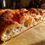 Close-up cross-section showing the airy, open crumb structure of sourdough discard pizza dough.