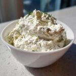 A close-up of thick, creamy 5-Minute Greek Yogurt Ranch Dip, garnished with fresh dill, served in a small white bowl.