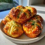 A stack of golden brown Air Fryer Garlic Knots topped with melted butter, Parmesan, and fresh parsley.