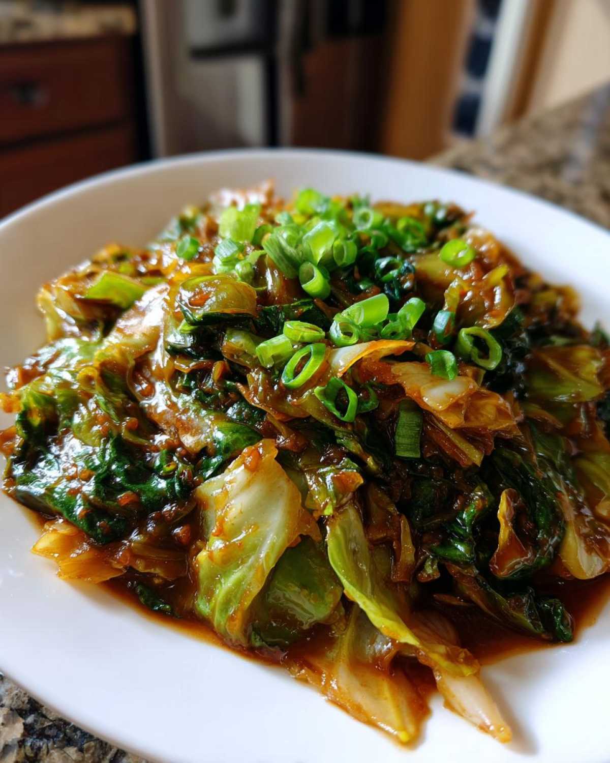 Close-up of a vibrant Cabbage Stir Fry with Garlic Ginger Sauce, topped with fresh green onions.