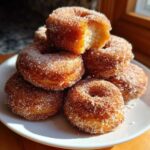 A tempting stack of golden Cinnamon Sugar Air Fryer Donuts heavily coated in sparkling sugar.