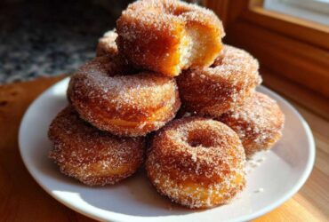 A tempting stack of golden Cinnamon Sugar Air Fryer Donuts heavily coated in sparkling sugar.