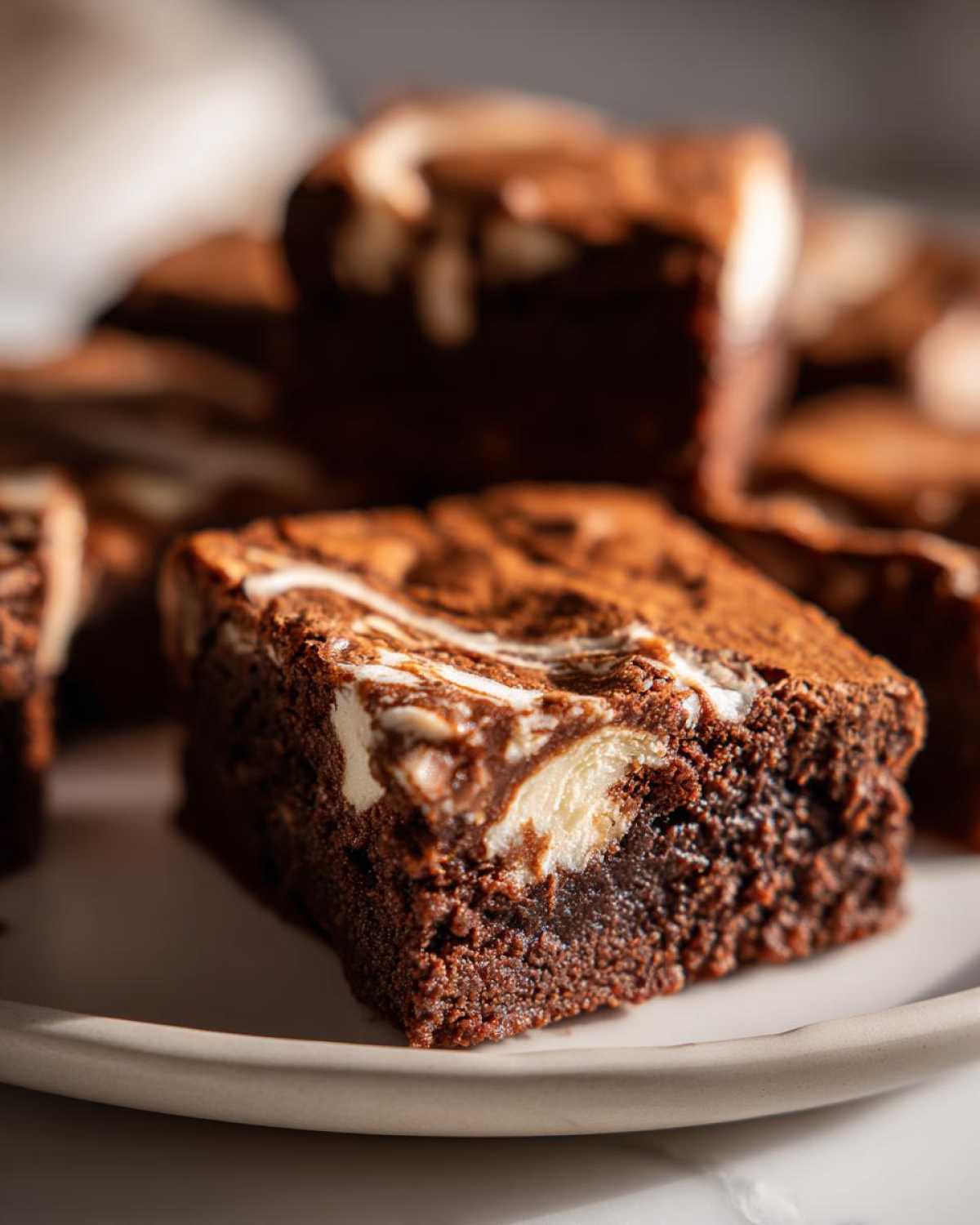 Close-up of a fudgy Dark Chocolate Tahini Brownies square with a white swirl topping.