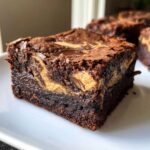Close-up of a fudgy Dark Chocolate Tahini Brownies square with a visible tahini swirl on top.