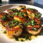 Close-up of perfectly seared Garlic Butter Scallops with Lemon, glistening in butter sauce and topped with fresh parsley.