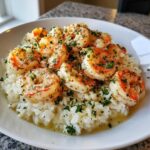 Plump shrimp coated in garlic butter and herbs served over white rice in a white bowl, perfect Garlic Butter Shrimp and Rice Skillet.