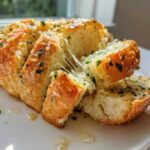Close-up of cheesy Garlic Parmesan Pull-Apart Bread being pulled apart, showing melted cheese strings.