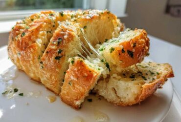 Close-up of cheesy Garlic Parmesan Pull-Apart Bread being pulled apart, showing melted cheese strings.
