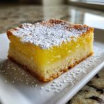 A close-up of one square slice of Gluten-Free Lemon Bars with Shortbread Crust, dusted heavily with powdered sugar.