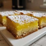 Close-up of square Gluten-Free Lemon Bars with Shortbread Crust topped with powdered sugar.