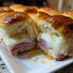Close-up of Hawaiian Roll Ham and Cheese Sliders cut in half showing melted cheese and ham.