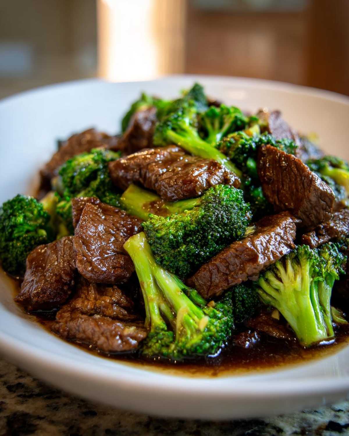 Close-up of tender slices of beef and bright green broccoli florets coated in a savory sauce from the Instant Pot Beef and Broccoli recipe.