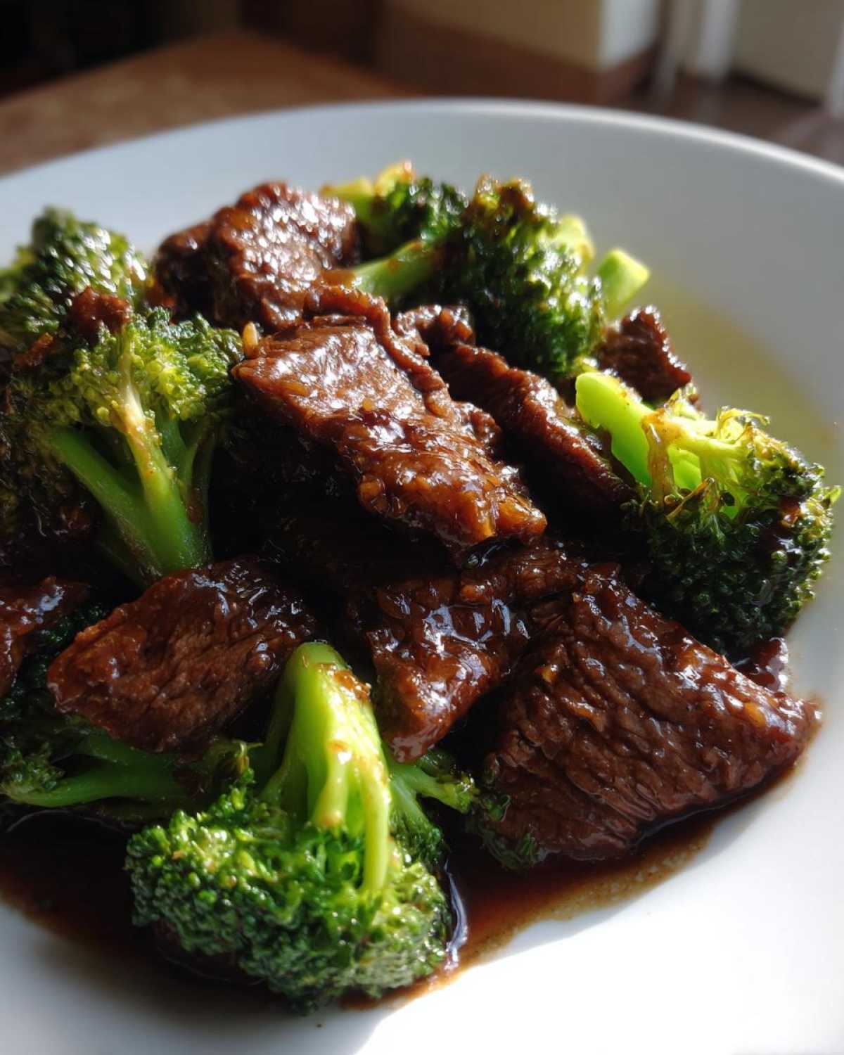 Close-up of tender slices of beef coated in savory sauce mixed with bright green broccoli florets, representing Instant Pot Beef and Broccoli.
