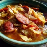 Close-up of a bowl of Instant Pot Cabbage and Sausage Soup featuring sliced sausage and tender cabbage.