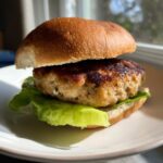 A perfectly cooked Air Fryer Turkey Burger patty resting on a bed of crisp lettuce inside a toasted bun.