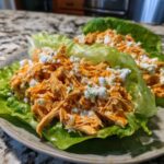 Close-up of Keto Buffalo Chicken Lettuce Wraps filled with shredded orange buffalo chicken and crumbled blue cheese.