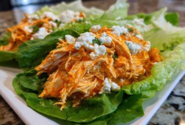 Close-up of Keto Buffalo Chicken Lettuce Wraps filled with shredded orange buffalo chicken and topped with crumbled blue cheese.